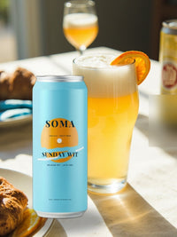SOMA Belgian Wit can on a sunny brunch table beside a wheat beer